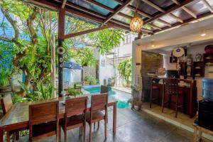 a dining room with a table and a swimming pool at RedDoorz near Pantai Sanur Bali in Sanur