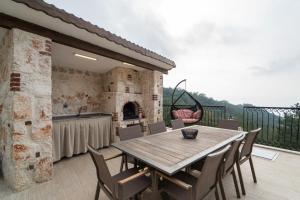 d'une terrasse avec une table et des chaises en bois ainsi qu'une cheminée. dans l'établissement Villa Valhalla, à Fethiye