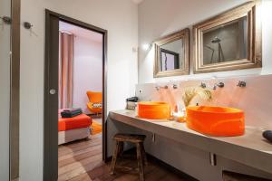 an orange bathroom with two sinks and a mirror at The Cosmopolitan Lodge in Cannes +27 photos