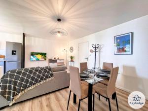 a living room with a couch and a table with chairs at Valeriane, classé 3 étoiles - T2 de 45 m2 à Sainte-Clotilde in Saint-Denis