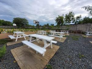 a group of white picnic tables and benches at RnB Stayction in Lapu Lapu City