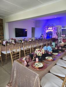 uma mesa longa com pratos de comida e cadeiras num quarto em Shotleft on Wye RD em Margate