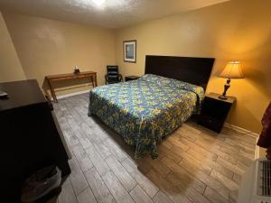 a hotel room with a bed and a desk at Cook's Motel in Panama City Beach