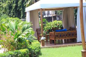 einen Pavillon mit Stühlen und Tischen im Garten in der Unterkunft Swahili House Mweru villa in Mombasa