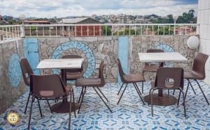 a group of tables and chairs on a balcony with a mural at Empire du Luxe in Yaoundé