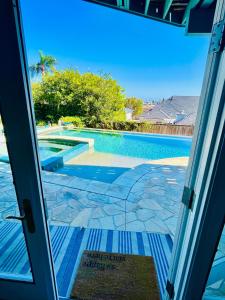 a door open to a swimming pool with a view at La Playa Place Getaway in San Diego