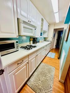 a kitchen with white cabinets and a stove top oven at La Playa Place Getaway in San Diego