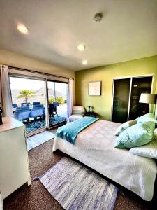 a bedroom with a large bed and a balcony at La Playa Place Getaway in San Diego