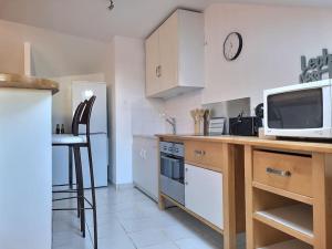 a kitchen with a counter with a microwave and a tv at Le Cosy à Quatre *Gare*Wifi*Paris*Disney* in Villiers-sur-Marne