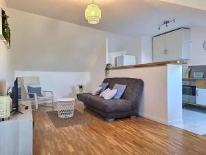 a living room with a couch and a kitchen at Le Cosy à Quatre *Gare*Wifi*Paris*Disney* in Villiers-sur-Marne