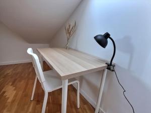 a desk with a lamp and a white chair at Le Cosy à Quatre *Gare*Wifi*Paris*Disney* in Villiers-sur-Marne