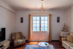 ein Wohnzimmer mit einer Tür und Meerblick in der Unterkunft WelcomeBuddy - Berço do Infante Sea View in Vila Franca do Campo