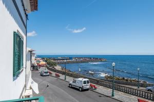 Ein weißer Van parkt auf einer Straße neben dem Meer in der Unterkunft WelcomeBuddy - Berço do Infante Sea View in Vila Franca do Campo