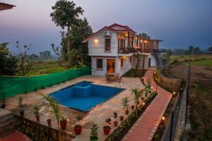 a house with a swimming pool in front of it at Pitaara Cottage in Kota Bāgh