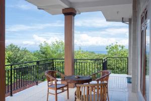 a porch with a table and chairs on a balcony at SDK Homestay Uluwatu in Uluwatu