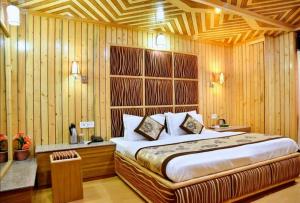 a bedroom with a bed and a wooden wall at Chaman Palace in Shimla