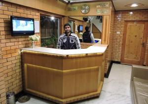 a man standing behind a bar in a restaurant at Chaman Palace in Shimla