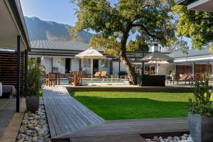 a house with a backyard with a wooden walkway at Aan de Eike Guest House in Swellendam