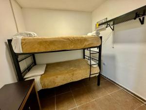 two bunk beds in a room with a table at Suites Apodaca in Monterrey