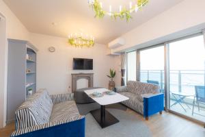 ein Wohnzimmer mit zwei Sofas und einem Tisch in der Unterkunft COSTA AKEBONO -Blanciera Naha Akebono Premist 1103- in Naha