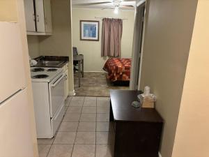 uma cozinha com um lavatório e um fogão num quarto em Cook's Motel em Panama City Beach