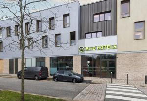 two cars parked in front of a building at B&B HOTEL Versailles Rocquencourt in Rocquencourt