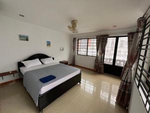 ein Schlafzimmer mit einem Bett und einem großen Fenster in der Unterkunft Errol's Homestay and Hostel in Siem Reap