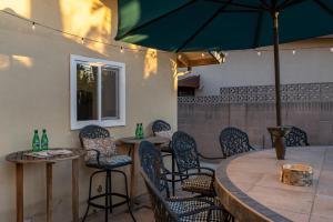 a restaurant with chairs and tables and an umbrella at Amazing Modern Pool House near Disneyland in Anaheim