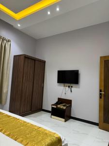 a bedroom with a bed and a flat screen tv at شقق سحاب الخليج المخدومة in Al Muzāḩimīyah