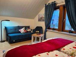 een woonkamer met een bed en een blauwe bank bij Ferienwohnung und -haus am Rennsteig bei Eisenach - Angela Jaentsch in Wolfsburg-Unkeroda