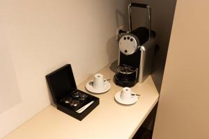 uma mesa com comodidades para preparar café e um relógio em Hotel Rondo - Self-Check-in em Wil