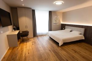 ein Schlafzimmer mit einem weißen Bett und einem großen Fenster in der Unterkunft Hotel Rondo - Self-Check-in in Wil