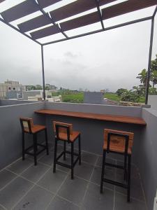 two chairs and a bar on a roof at Villa Royal Arois Syariah Dekat Jatim Park 3 in Tlekung