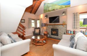 a living room with white furniture and a fireplace at Alder Cottage in Blairmore