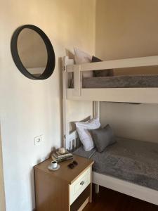 a small room with a bunk bed and a mirror at Hostel on the Hill - by Filikuri Beach in Himare