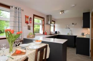 a kitchen with a table with a vase of flowers at Alder Cottage in Blairmore