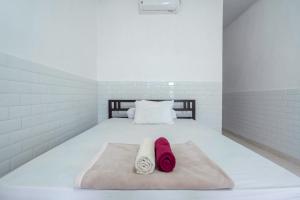 a bedroom with a bed with two towels on it at SDK Homestay Uluwatu in Uluwatu