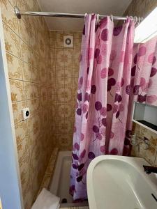 a bathroom with a pink shower curtain and a sink at Hotel Hecht in Sennwald