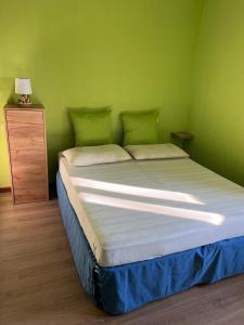 Ce lit se trouve dans un dortoir doté d'un mur vert. dans l'établissement VALPOCENTER - Baita dei Fiori, à SantʼAnna dʼAlfaedo