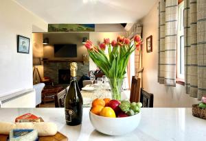 Eine Vase mit Blumen und eine Schale mit Obst auf einem Tisch. in der Unterkunft Alder Cottage in Blairmore + 14 Fotos