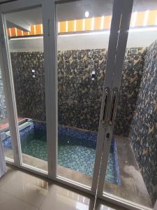 a view of a swimming pool through a window at Villa Royal Arois Syariah Dekat Jatim Park 3 in Tlekung