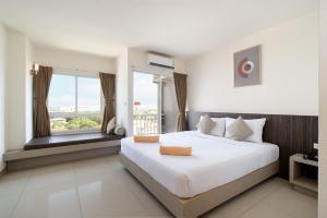 a bedroom with a large bed and a large window at Leenova Hotel in Bangkok