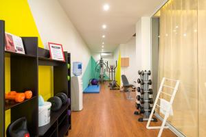 a room with a gym with dumbbells and weights at Trypiti Resort Blue Dream Palace and Hive Water Park in Limenaria