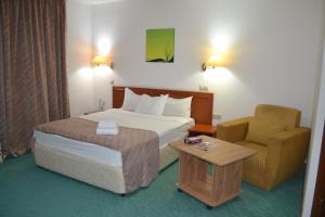 Habitación de hotel con cama y silla en Tengri Hotel, en Atyraū