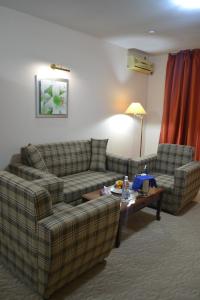 a living room with two couches and a coffee table at Tengri Hotel in Atyrau