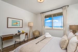 een slaapkamer met een bed, een bureau en een raam bij @Marbella Lane - 7BR home w/ Mountain+Ocean Views in Waianae