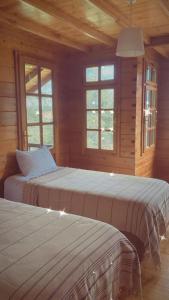 2 letti in una camera in legno con finestre di Sakli Kosk Kartepe a Kartepe