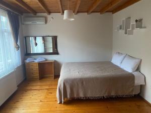 a bedroom with a bed and a dresser and a window at Sakli Kosk Kartepe in Kartepe