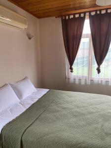 a bedroom with a bed and a window at Sakli Kosk Kartepe in Kartepe