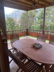 - une table et des chaises en bois sur une terrasse couverte avec moustiquaire dans l'établissement Sakli Kosk Kartepe, à Kartepe